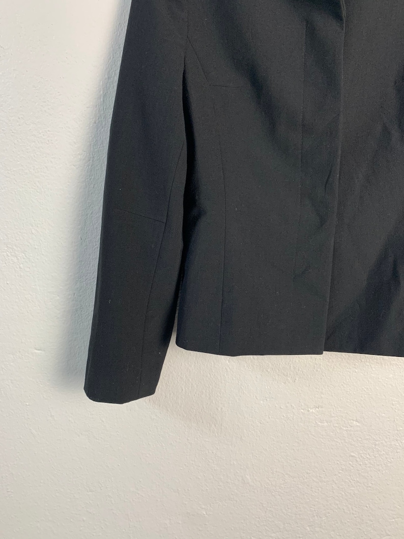 May include: A black blazer with long sleeves and a button closure.