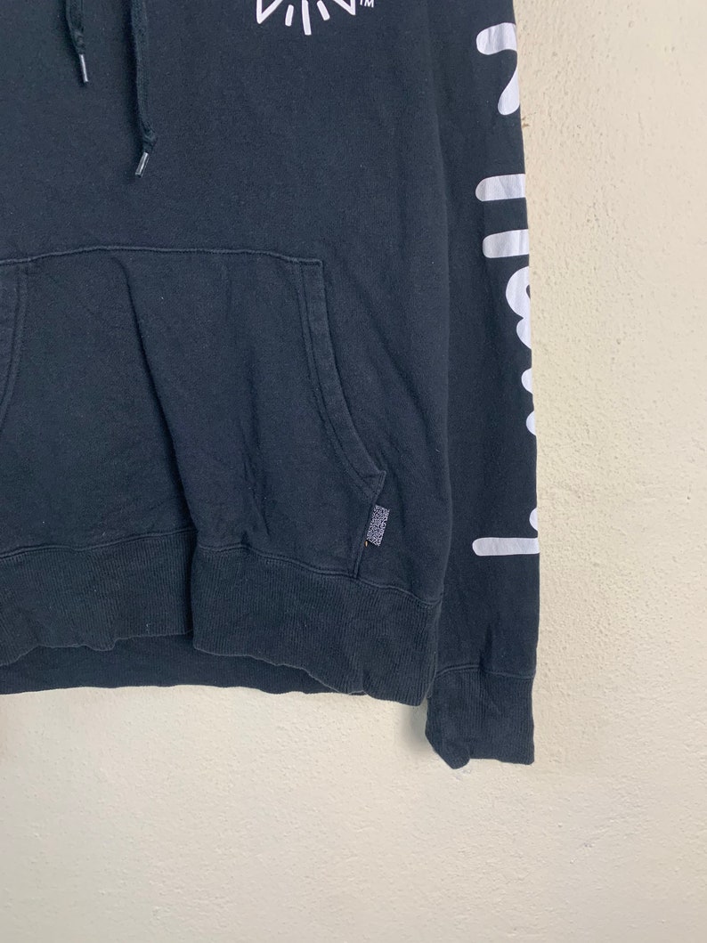 May include: Black hooded sweatshirt with white graphic print on the sleeve and a small white graphic print on the front. The print on the sleeve says "chillwave".