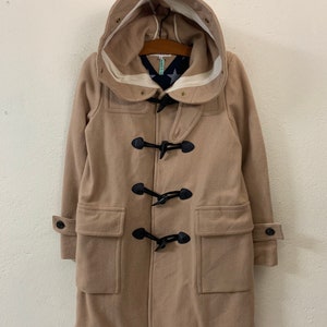 May include: A beige hooded duffle coat with black toggle closures and two front pockets.