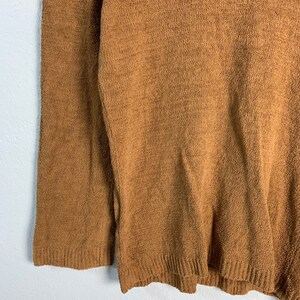 Puede incluir: Un su&eacute;ter marr&oacute;n de manga larga con textura acanalada.