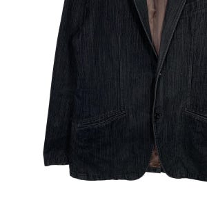 May include: A black corduroy blazer with a single button closure and two front pockets.