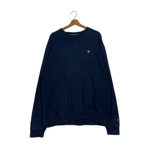 Puede incluir: Una sudadera Champion azul marino con un pequeño logotipo blanco en el pecho izquierdo.