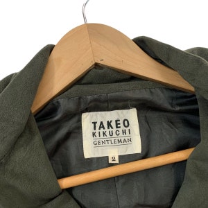 May include: A green hooded jacket with a black label that reads "TAKEO KIKUCHI GENTLEMAN" and the number "2" on it.
