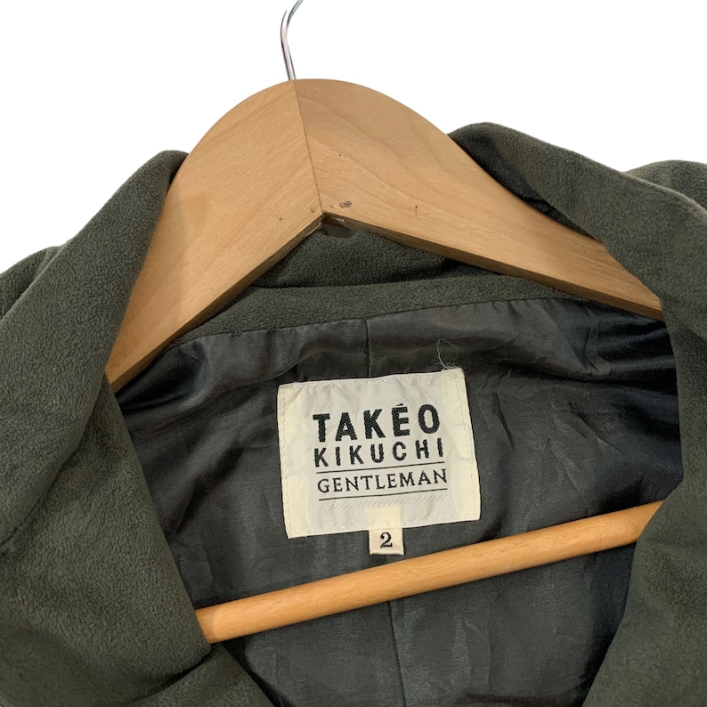 May include: A green hooded jacket with a black label that reads "TAKEO KIKUCHI GENTLEMAN" and the number "2" on it.