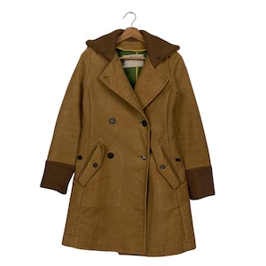 May include: A tan double-breasted coat with a brown knit collar and cuffs. The coat has black buttons and two front pockets. The coat is hanging on a wooden hanger.