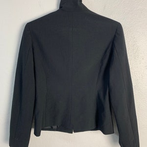 May include: A black blazer with a mock neck collar and long sleeves.