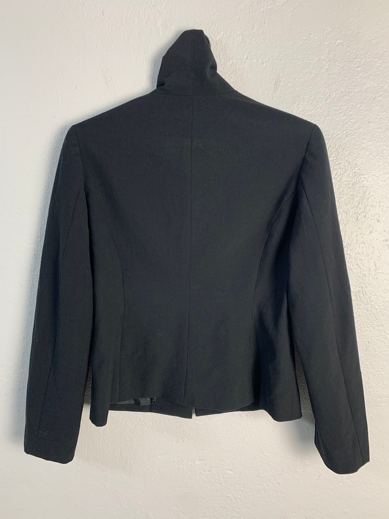 May include: A black blazer with a mock neck collar and long sleeves.