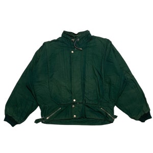 以下が含まれることがあります： 襟が高く、ジッパーで閉めることができる、濃い緑色のジャケット。首に紐があり、ウエストにベルトが付いている。