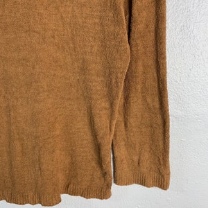 Puede incluir: Un su&eacute;ter marr&oacute;n de manga larga hecho de un material suave y peludo.