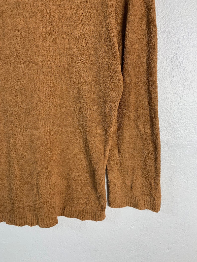 Puede incluir: Un su&eacute;ter marr&oacute;n de manga larga hecho de un material suave y peludo.