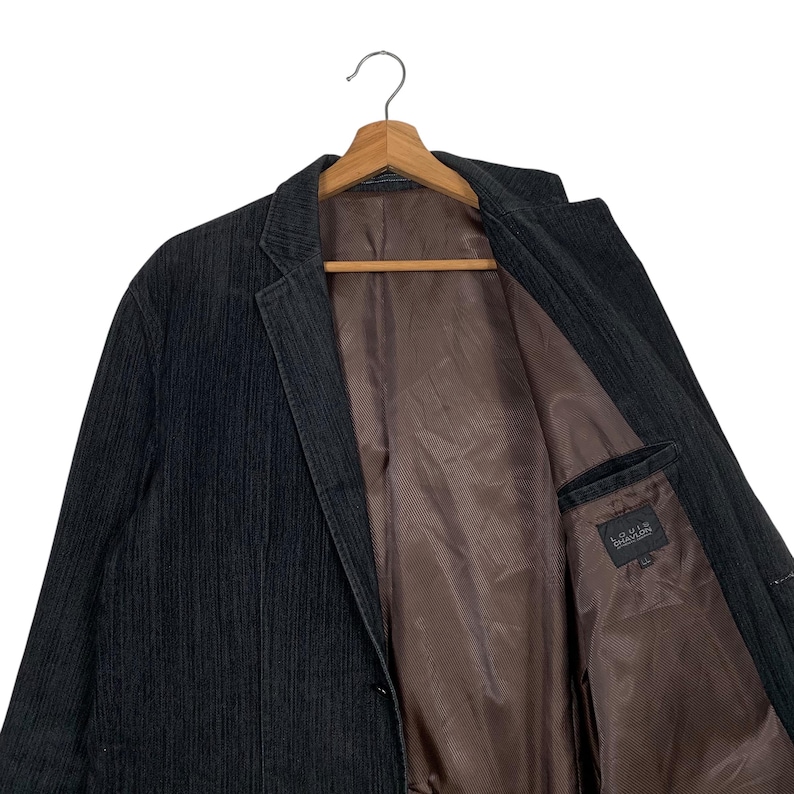 May include: A black corduroy blazer with a brown lining and a small label that says "Louis Delacroix" in the inside pocket.