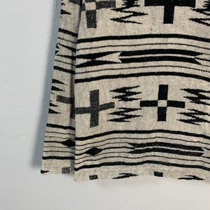 Puede incluir: Tejido tejido en blanco y negro con un patr&oacute;n geom&eacute;trico que presenta cruces y zigzags.