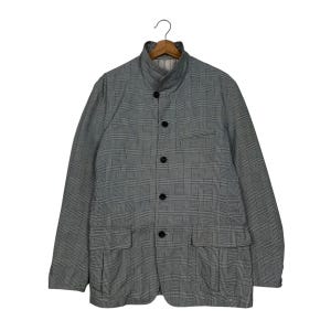 May include: A grey and white checked jacket with a mandarin collar and four black buttons. The jacket features two front pockets and a small chest pocket. It is displayed on a wooden hanger.