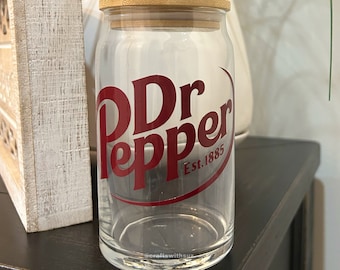 May include: A clear glass jar with a wooden lid and a red Dr Pepper logo that says "Est. 1885".
