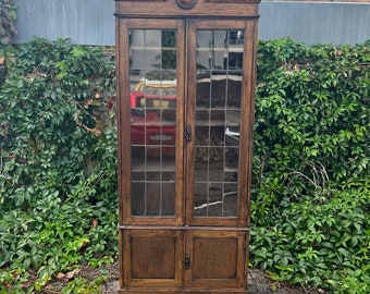 Vitrina inglesa antigua con puertas de cristal emplomado.