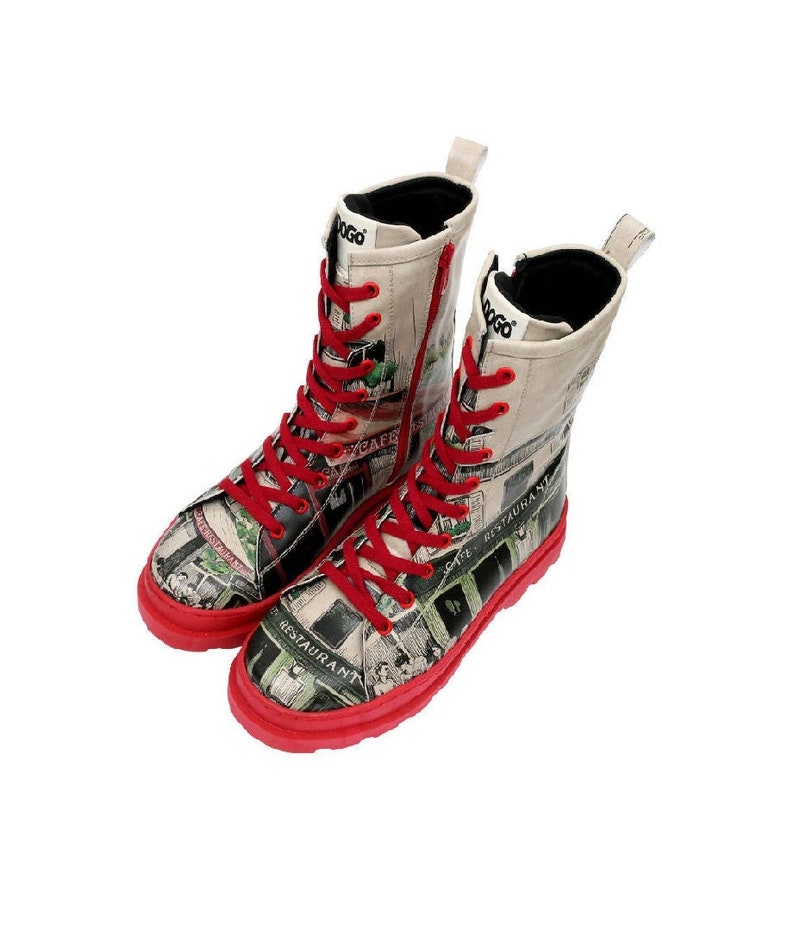 May include: A pair of red and white high-top boots with a black zipper and red laces. The boots are covered in a print of a city scene with buildings, streets, and text like "Cafe Restaurant".