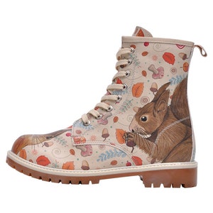 Può includere: Stivali in pelle beige con chiusura a lacci e suola in gomma marrone. Gli stivali presentano una stampa colorata di scoiattoli, funghi, foglie e ghiande.