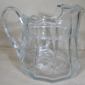 May include: A set of three ceramic mugs with a speckled, matte finish. The mugs are in shades of cream, light gray, and dark gray. Each mug has a simple, minimalist design and a rounded handle.