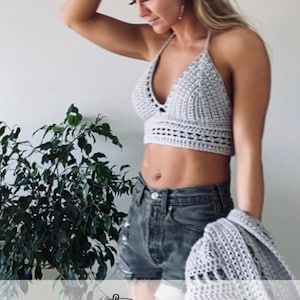 May include: A light gray crochet halter top and matching shawl. The top has a deep V-neck and a textured stitch pattern. The shawl is draped over the arm. The text "Taylor-Made Crafts" is at the bottom of the image.