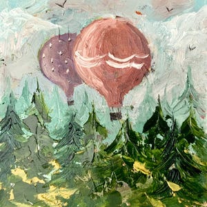 May include: An oil painting depicts two hot air balloons floating above a forest of green trees. One balloon is mauve, the other is a dusty rose color. The sky is a light blue with white clouds and a few birds.