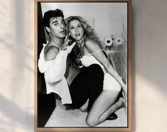 May include: A black and white photograph of a man and a woman in a bathroom. The man is wearing a white shirt and the woman is wearing a white bikini top. They are both looking at the camera.