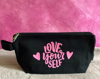 May include: Black canvas makeup bag with a pink zipper and the words "LOVE your SELF" in pink lettering with two pink hearts.