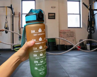 May include: A gradient water bottle in shades of brown and green, held by a hand. The bottle has a blue lid and a matching strap. White text indicates time-based hydration goals, including "GET STARTED" and "REFILL".