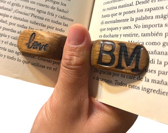 May include: Two wooden bookends with the words "love" and "BM" carved into them. The bookends are brown and have a natural wood finish.