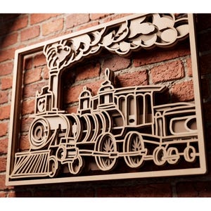 Può includere: Un'opera d'arte da parete in legno multistrato che raffigura una locomotiva a vapore dettagliata. Il design include un fumaiolo che emette nuvole di fumo stilizzate, un para-mucche e diverse ruote, il tutto incorniciato da un bordo rettangolare.
