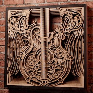 Peut inclure: Une décoration murale carrée en bois multicouche représentant une silhouette de guitare centrale intégrée à des motifs d'engrenages mécaniques, flanquée de deux grandes ailes détaillées. Le design utilise des tons de bois naturels variés.