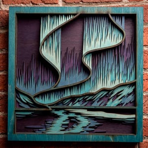 May include: A square layered wooden wall art piece featuring a stylized depiction of the aurora borealis. The design uses shades of teal, light blue, and deep purple, with intricate cutouts creating a sense of depth and movement in the sky.