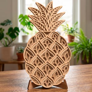 Può includere: Una scultura di ananas in legno a strati con dettagli intricati. La scultura è realizzata in legno marrone chiaro e scuro, con una corona di foglie dettagliata. Si erge su un supporto in legno, mostrando un design artistico unico. L'ananas è alta circa 30 cm.