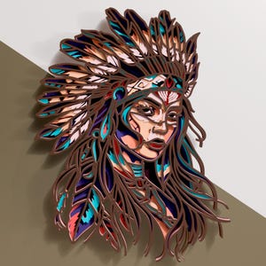 Puede incluir: Una obra de arte mural de madera en capas que representa a una mujer nativa americana con un tocado de plumas. La obra de arte presenta un diseño detallado con varios colores, incluyendo marrón, azul, rojo y blanco. La pieza está montada sobre un fondo neutro.