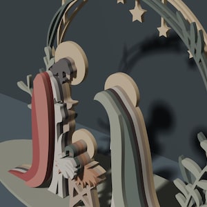 May include: A layered wooden nativity scene featuring stylized figures of Mary, Joseph, and the infant Jesus. The figures are set against a circular arch decorated with leaf motifs and hanging stars, rendered in a muted palette of sage green, tan, and dusty rose.