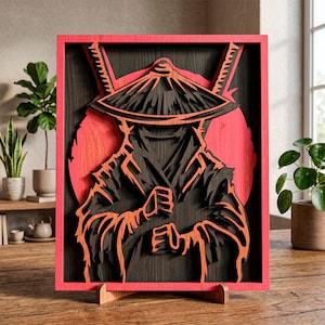 May include: A layered wooden art piece featuring a samurai warrior in black and orange tones, set against a red backdrop. The artwork is framed in a vibrant red, with a wooden stand. The samurai is depicted with a hat and swords.