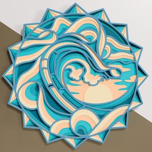 May include: A layered paper art piece depicting a stylized ocean wave with a setting sun. The artwork features shades of blue, teal, and peach, arranged in concentric circles within a star-shaped frame. The design evokes a sense of tranquility.