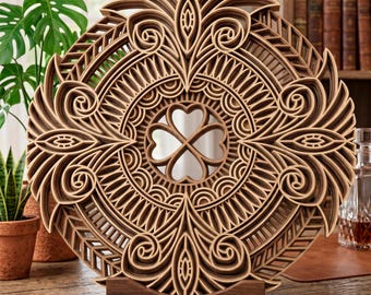 May include: A decorative wooden wall art piece with a layered design. The circular artwork features intricate patterns, including a four-leaf clover in the center. The piece is supported by a wooden stand and is displayed on a wooden surface.