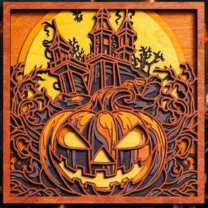 May include: A square wooden wall art piece featuring a layered, laser-cut design. The scene depicts a large, grinning jack-o'-lantern in the foreground, a haunted house with towers in the background, and a bright yellow full moon, all in orange, purple, and yellow.