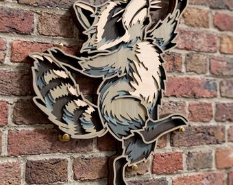 May include: A multi-layered wooden wall art piece depicting a raccoon in a dynamic pose. The raccoon features shades of natural wood, dark brown, and grey, with intricate cutouts creating a three-dimensional effect. It is mounted on a brick wall.