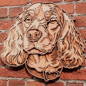 May include: A multi-layered wooden wall art piece depicting the head of a spaniel dog. The artwork features intricate laser-cut details in varying shades of light and medium brown wood, creating a dimensional effect that highlights the fur texture.