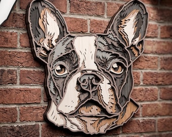 May include: A multi-layered wooden wall art piece shaped like a French Bulldog head. The design features stacked laser-cut wood panels in shades of dark brown, light tan, and cream, creating a dimensional relief effect of the dog's face.