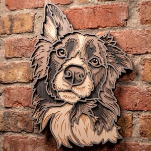 May include: A multi-layered wooden wall art piece depicting the head of a dog with pointed ears. The artwork features various shades of brown, tan, and dark wood tones, creating a dimensional effect with intricate cutouts defining the fur texture.