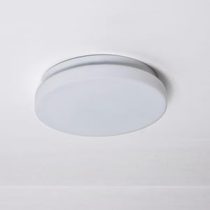 Könnte beinhalten: Eine runde, weiße Deckenleuchte mit einem Schirm aus mattiertem Glas. Die Leuchte hat ein schlichtes, modernes Design und ist bündig an einer weißen Decke montiert. Die Leuchte hat eine Scheibenform mit leicht erhöhtem Rand.
