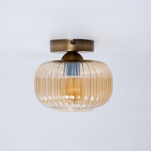 May include: A gold ceiling light fixture with a ribbed amber glass shade.