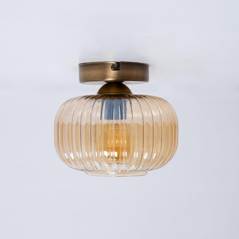 May include: A gold ceiling light fixture with a ribbed amber glass shade.