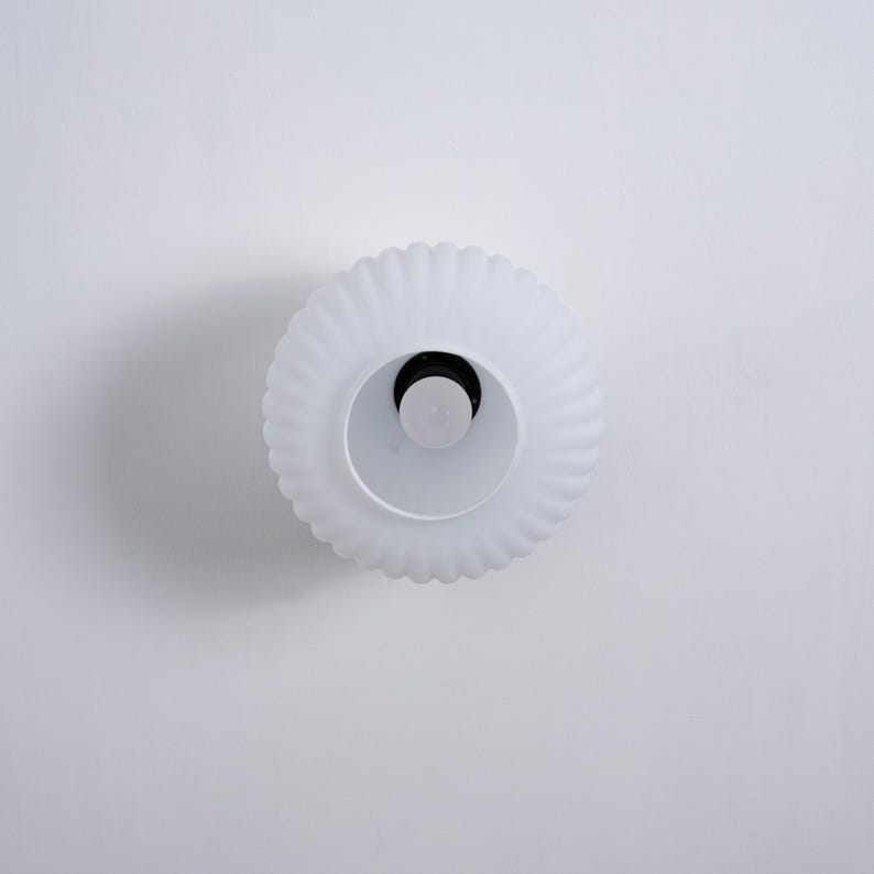 May include: White ceiling light fixture with a fluted glass shade.