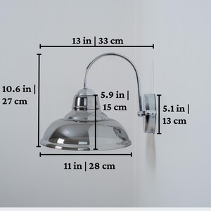 May include: Chrome wall sconce with a smoked glass shade. The sconce is 13 inches wide, 10.6 inches tall, and the shade is 11 inches wide.