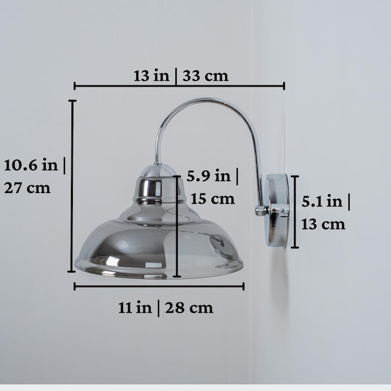 May include: Chrome wall sconce with a smoked glass shade. The sconce is 13 inches wide, 10.6 inches tall, and the shade is 11 inches wide.