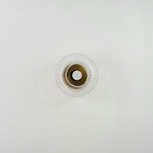 Op de afbeelding: Een glazen lampenkap van helder glas met een geribbelde textuur en een messing middenring. De lampenkap is rond en heeft een witte achtergrond.