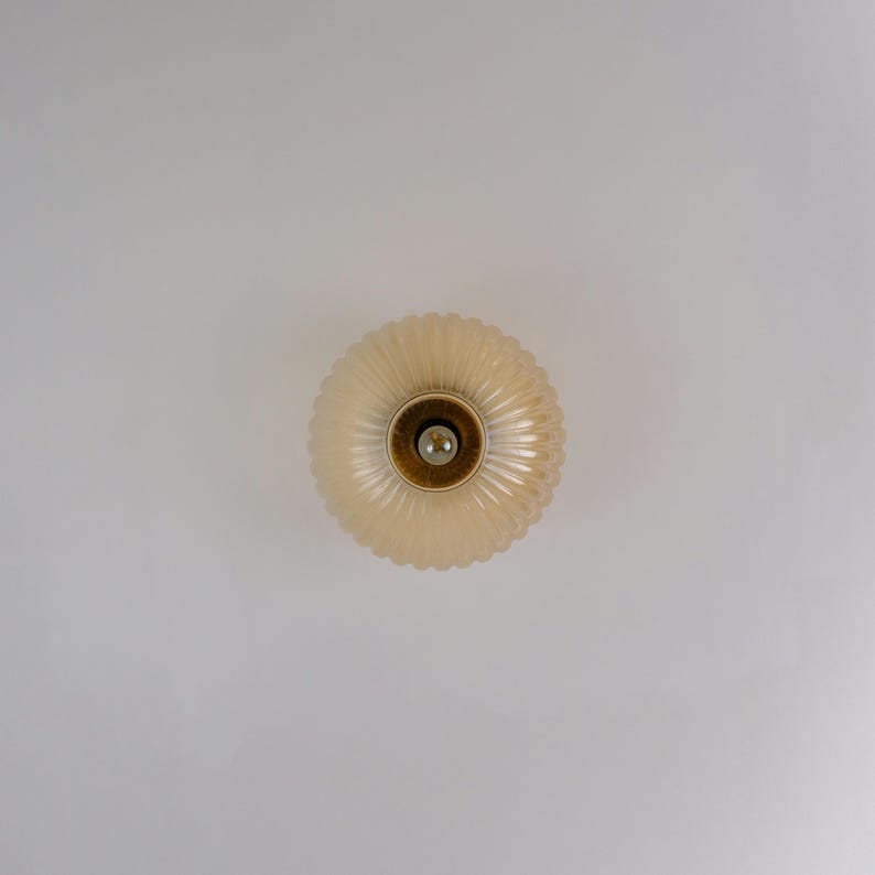 May include: A white ceiling light fixture with a round, ribbed glass shade.